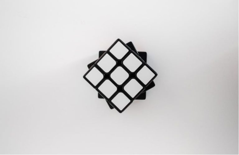 Rubics cube showing only white squares made up, on a white background.