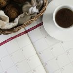 Diary page open with coffee cup sitting alongside it